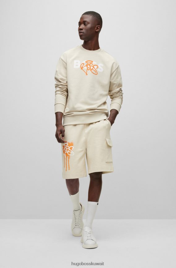 4TFNJN1532 البيج الفاتح Hugo Boss سويت شيرت من القطن من Hugo بقصة مريحة مع عمل فني بشعار جرافيتي باللون البيج الفاتح