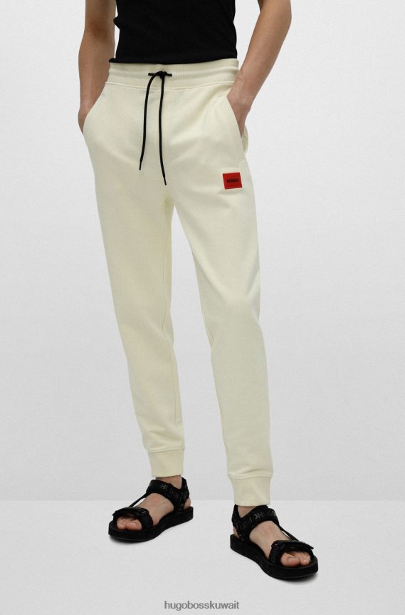 4TFNJN2078 أصفر فاتح Hugo Boss قطعة سفلية من بدلة رياضية من القطن باللون الأصفر الفاتح من Hugo مع رقعة شعار حمراء