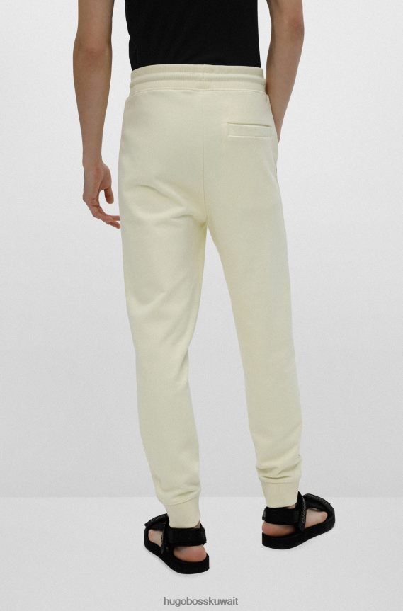 4TFNJN2078 أصفر فاتح Hugo Boss قطعة سفلية من بدلة رياضية من القطن باللون الأصفر الفاتح من Hugo مع رقعة شعار حمراء