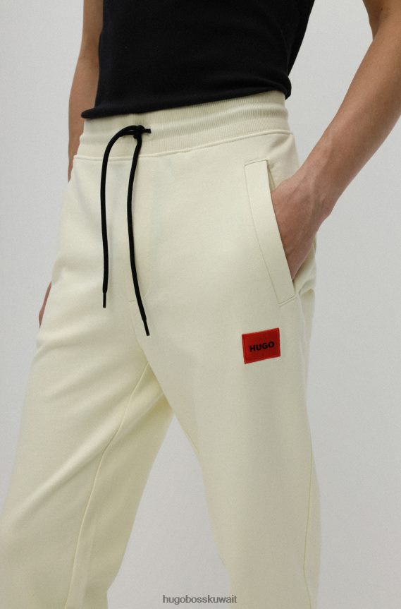 4TFNJN2078 أصفر فاتح Hugo Boss قطعة سفلية من بدلة رياضية من القطن باللون الأصفر الفاتح من Hugo مع رقعة شعار حمراء